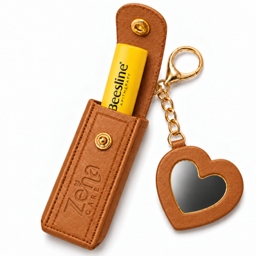 ZeinaCare brown lip pouch with yellow Beesline lip balm partially pulled out and matching heart mirror.